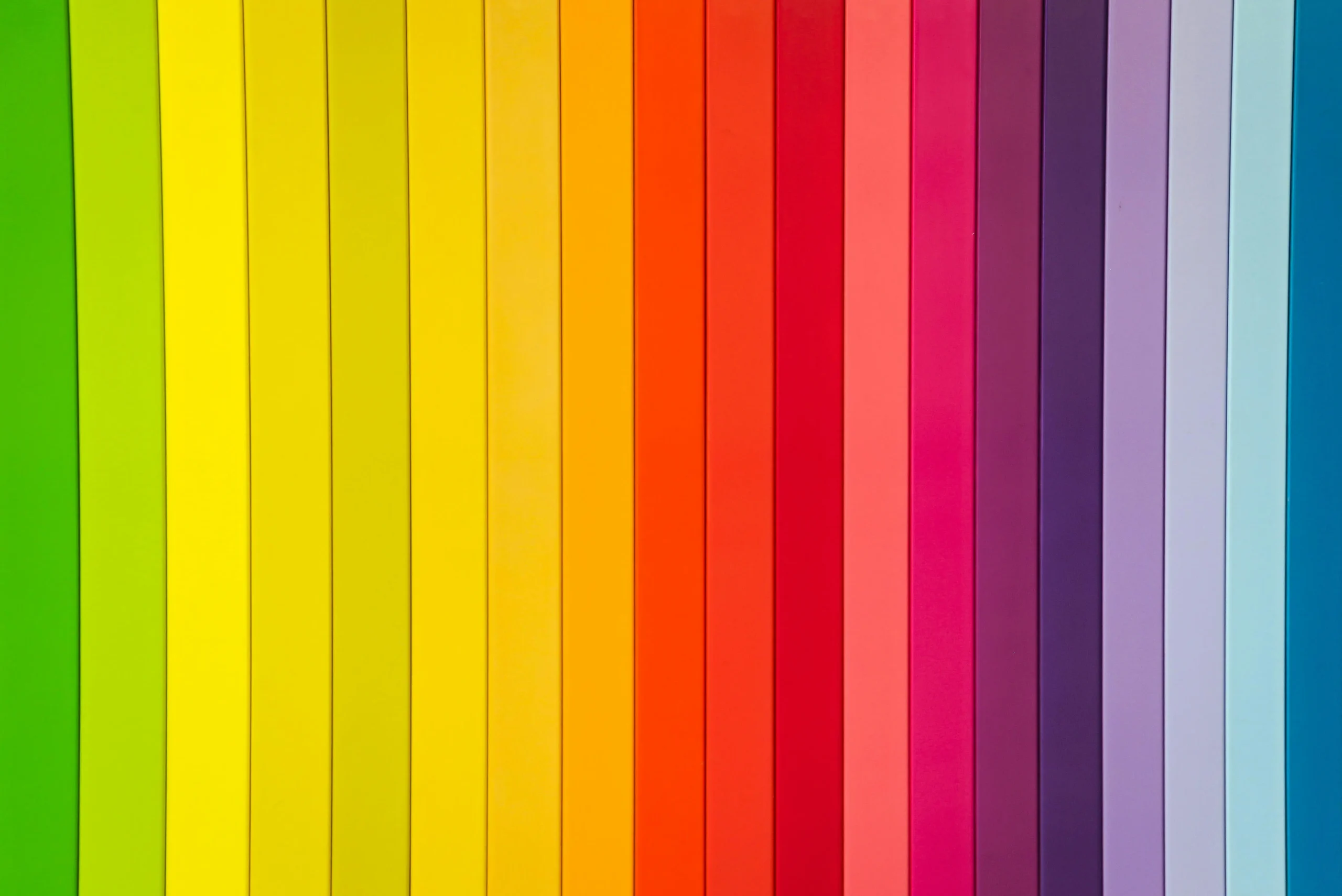 Vertical stripes in rainbow colors arranged side by side, progressing from green through yellow, orange, red, pink, purple, and blue, creating a vibrant spectrum pattern.