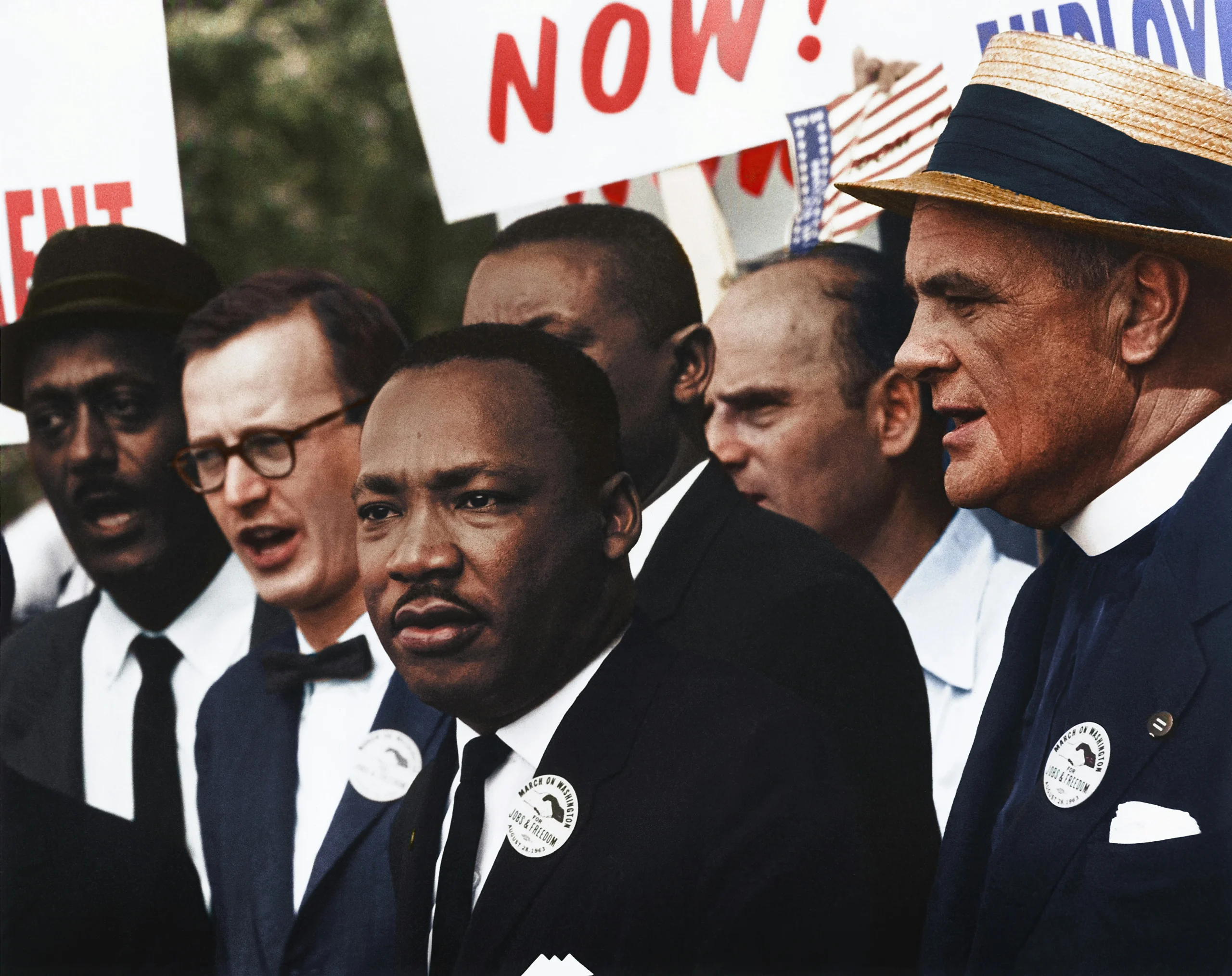 Protestors at a civil rights demonstration, including Dr. Martin Luther King Jr. in the center, wearing suits and 